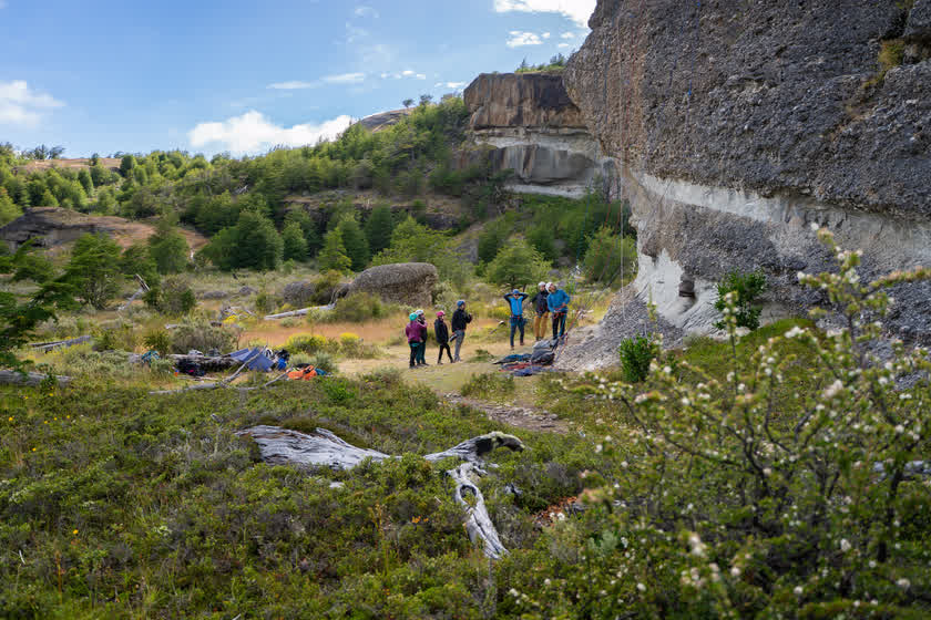Un grupo reunido al pie del Cerro Benítez, con la muralla de roca detrás
